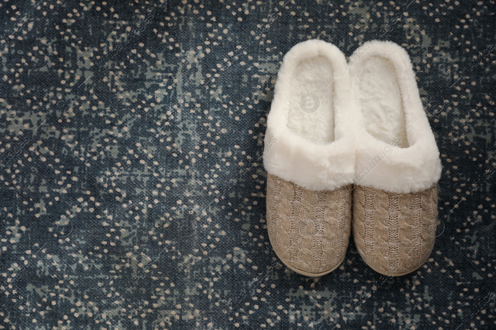 Photo of Pair of beautiful soft slippers on carpet, top view. Space for text