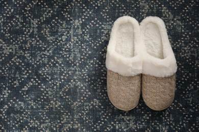 Pair of beautiful soft slippers on carpet, top view. Space for text