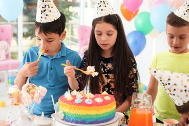 Photo of Happy children eating delicious cake at birthday party indoors