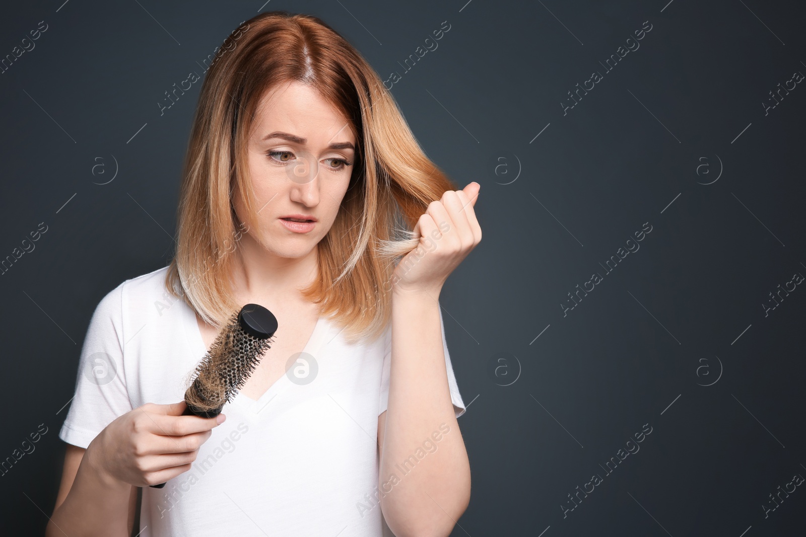 Photo of Young woman with hair loss problem on gray background