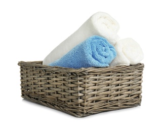 Rolled soft terry towels in wicker basket on white background