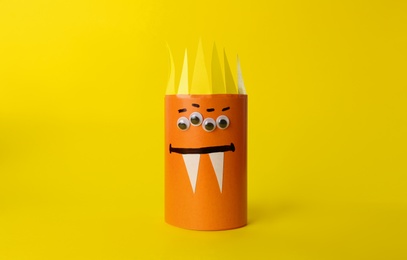 Photo of Funny orange monster on yellow background. Halloween decoration