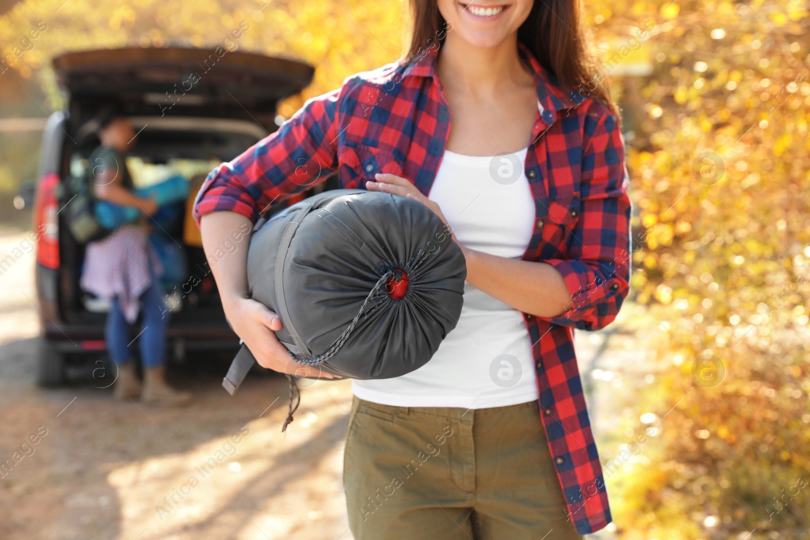 Photo of Female camper with sleeping bag outdoors, closeup