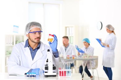 Male scientist working at table in laboratory, space for text. Research and analysis