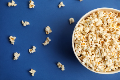 Tasty pop corn on blue background, flat lay