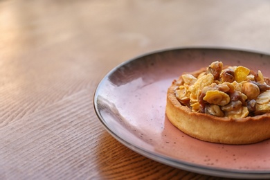 Photo of Plate with delicious cake on wooden table