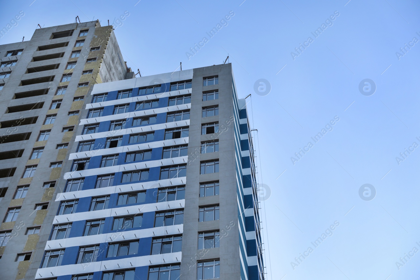Photo of Unfinished building against blue sky. Space for text