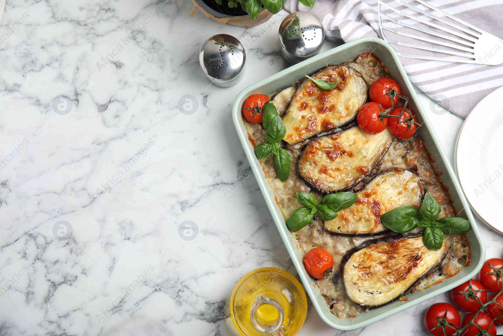 Photo of Delicious eggplant lasagna in baking dish on white marble table, flat lay. Space for text