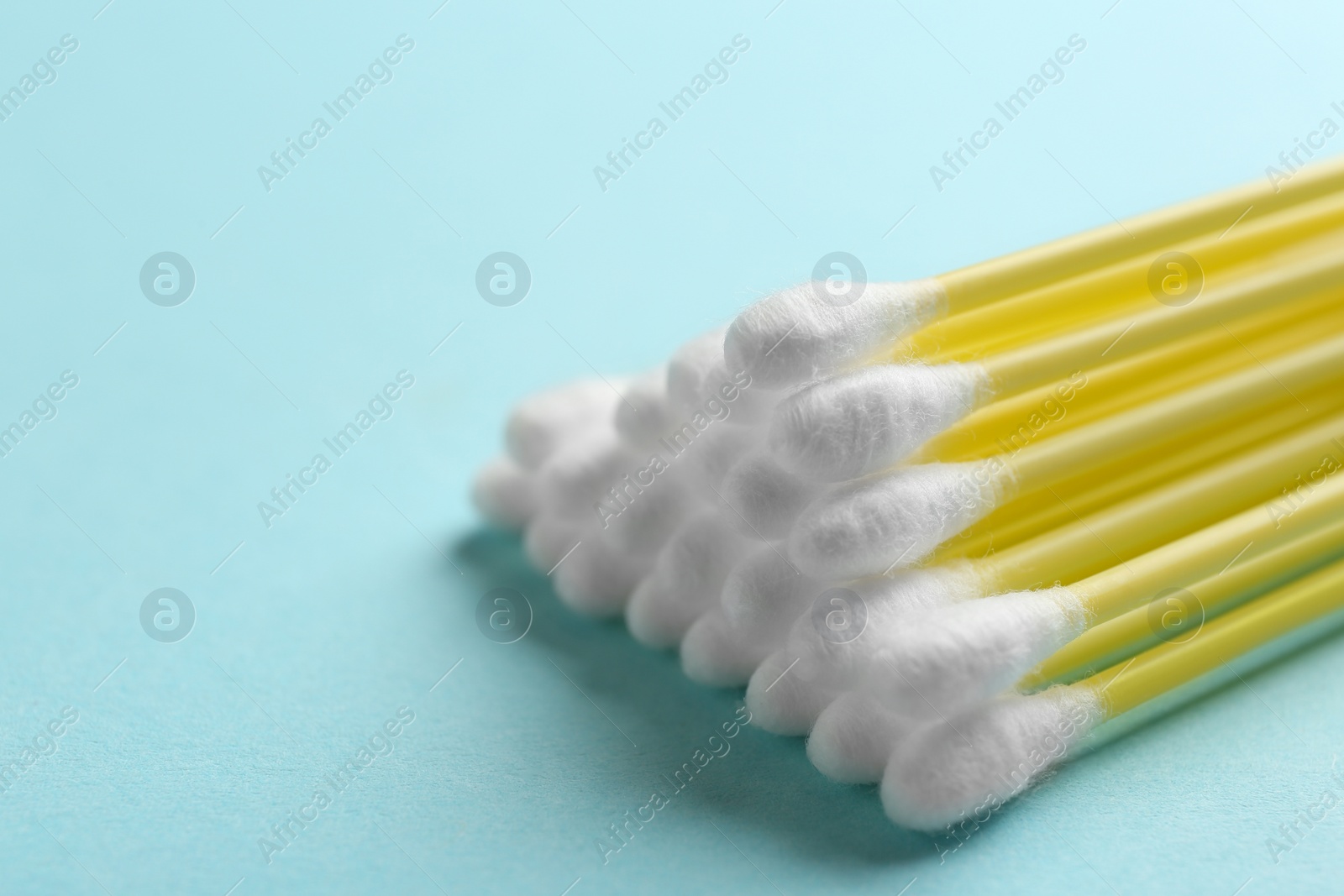 Photo of Pile of cotton swabs on color background, closeup. Space for text