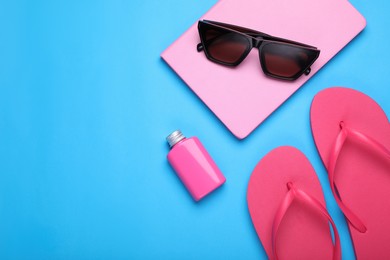 Photo of Flat lay composition with beach accessories on light blue background. Space for text