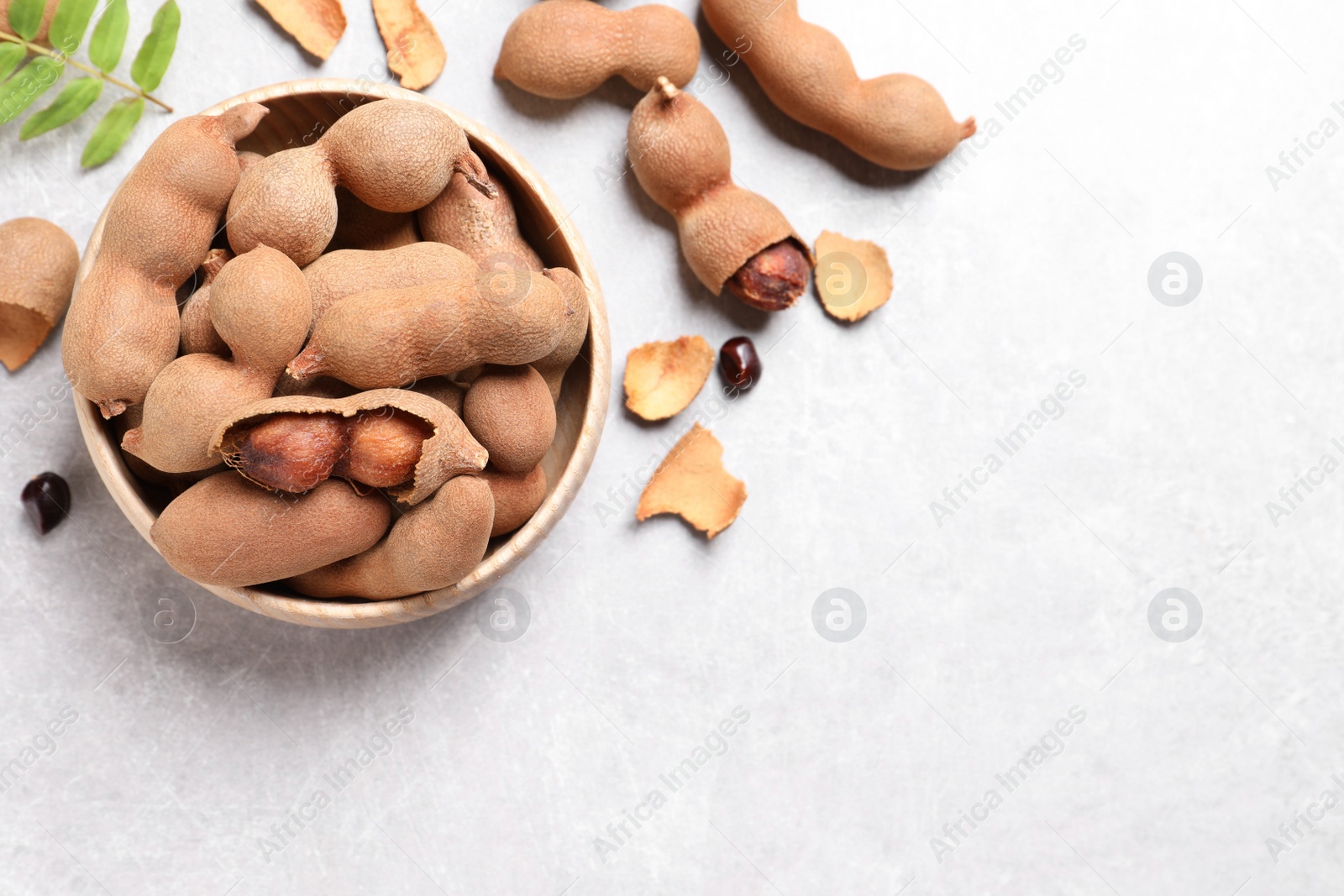 Photo of Delicious ripe tamarinds on light table, flat lay. Space for text