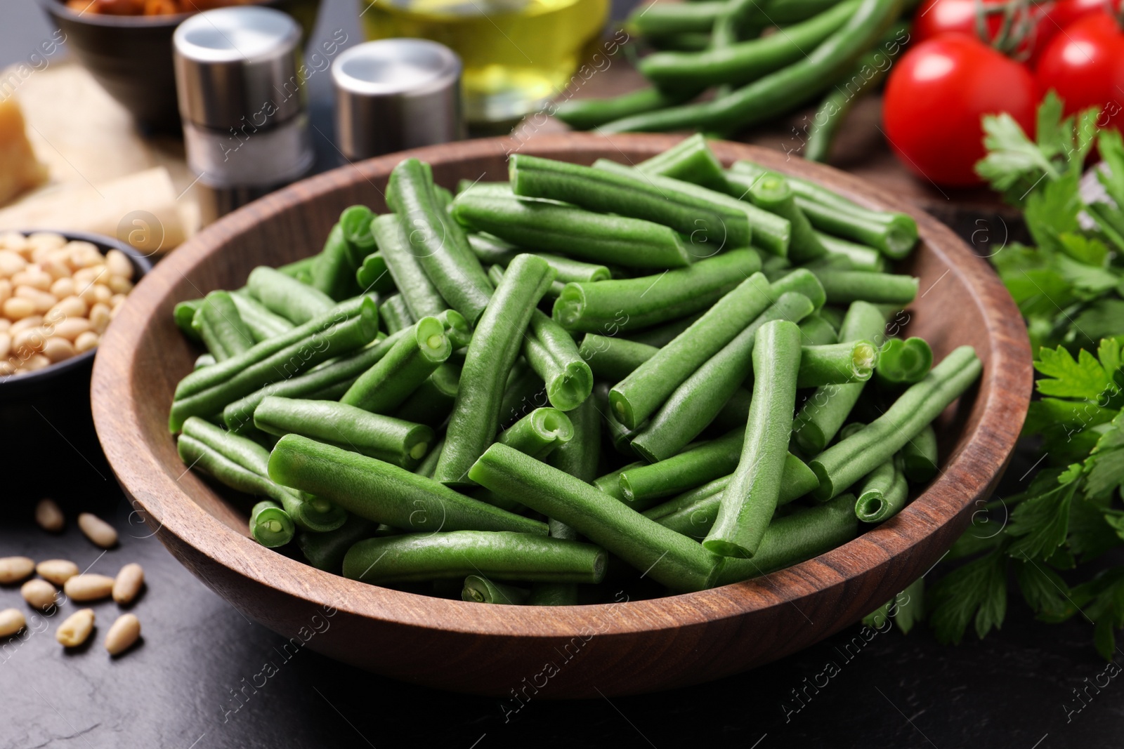 Photo of Fresh raw green beans and other ingredients for salad on table, closeup