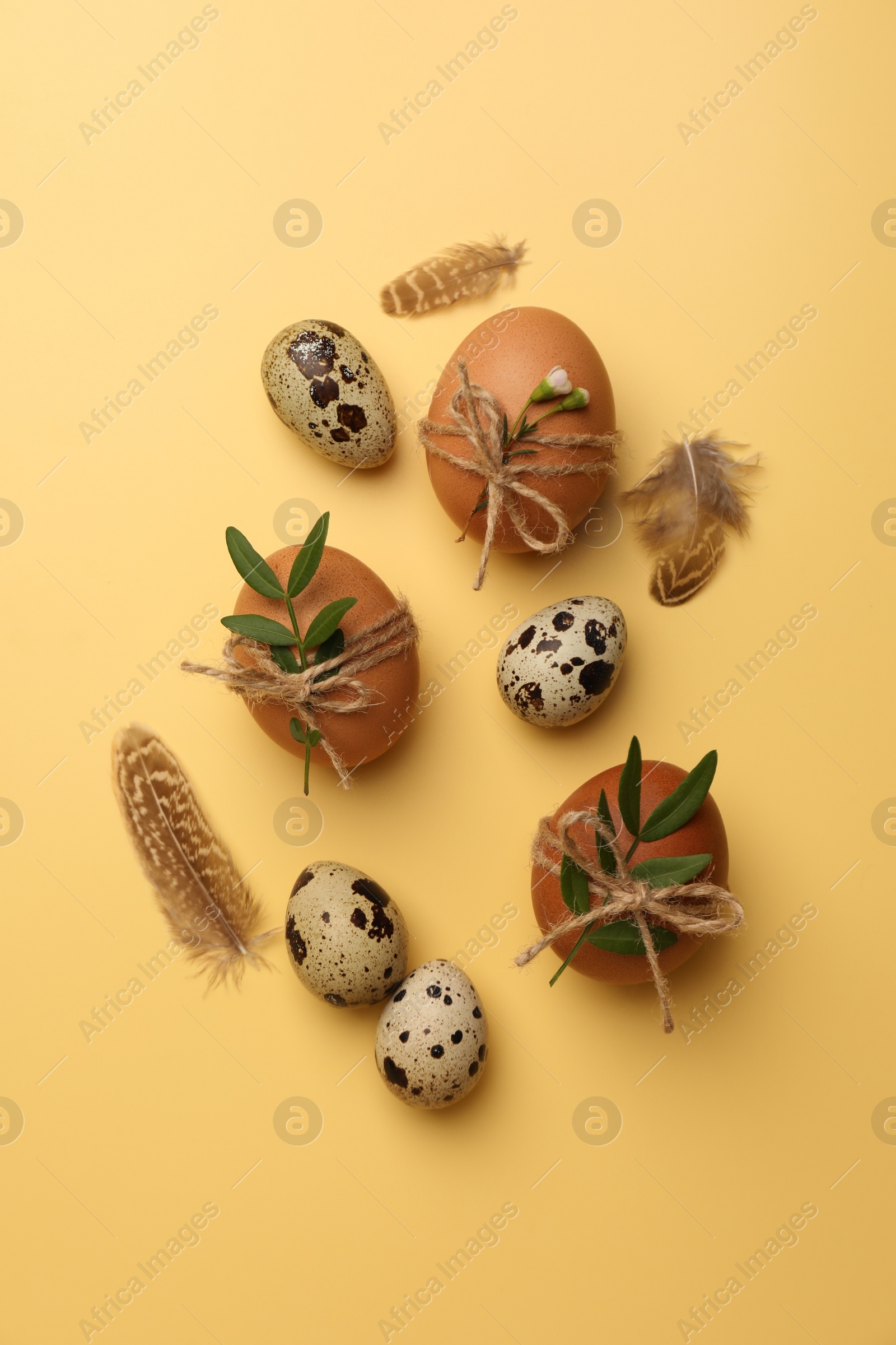 Photo of Festively decorated eggs on yellow background, flat lay. Happy Easter