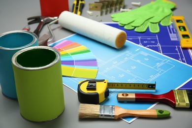 Photo of Set of decorator's tools and project drawings on table