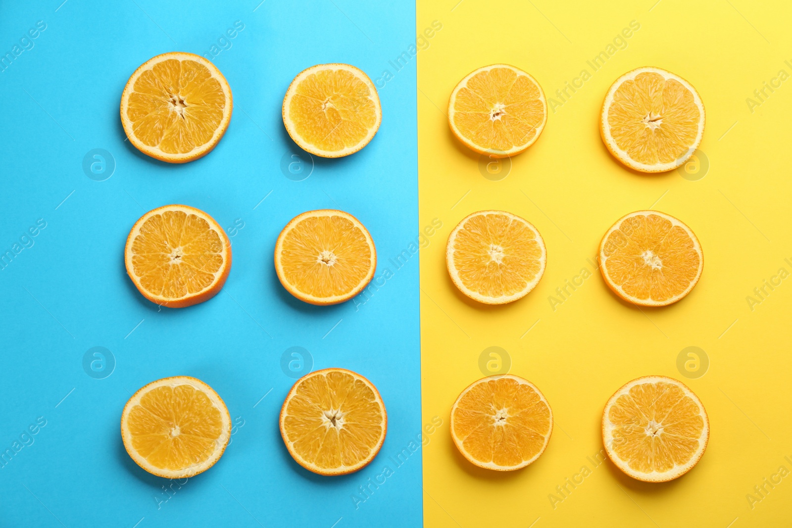 Photo of Slices of delicious oranges on color background, flat lay