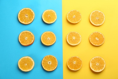 Slices of delicious oranges on color background, flat lay