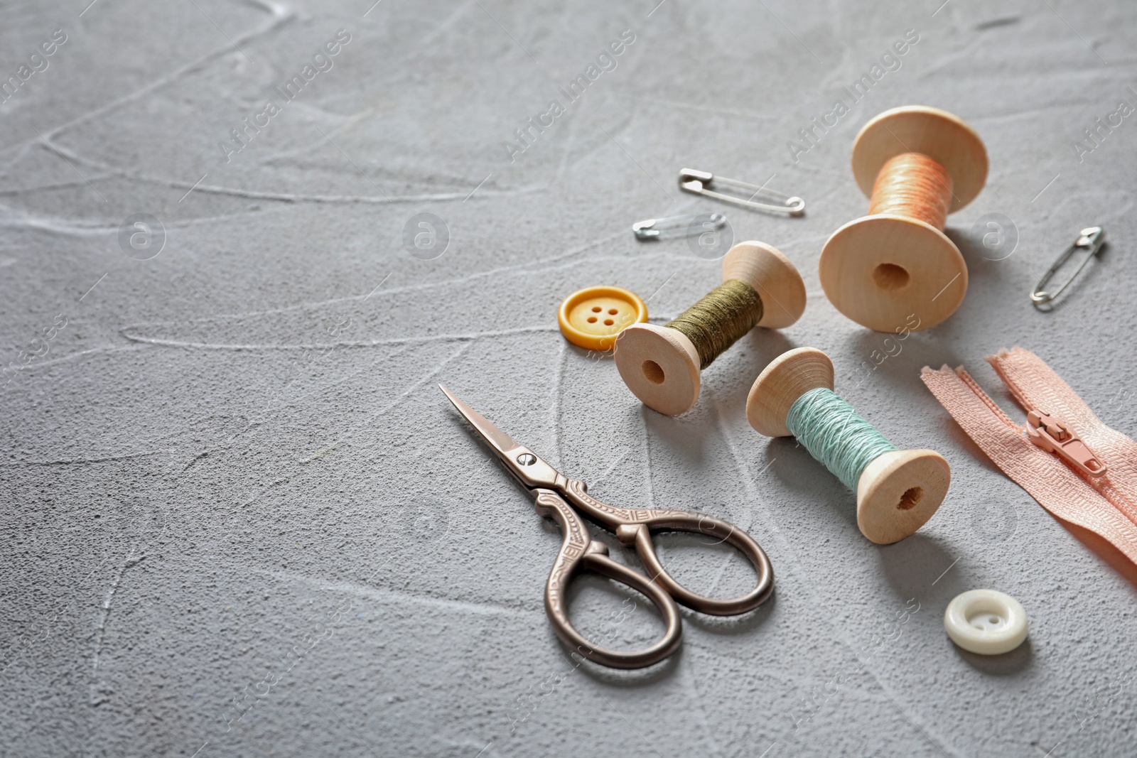 Photo of Set of tailoring accessories on grey background