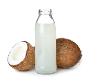 Photo of Bottle of coconut water and fresh nuts on white background