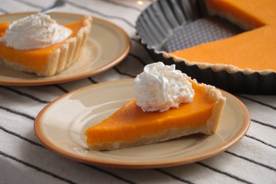 Photo of Fresh homemade pumpkin pie with whipped cream on table