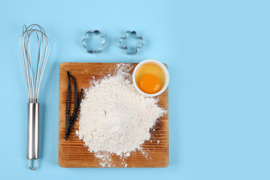 Photo of Flat lay composition with eggs and other ingredients on light blue background, space for text. Baking pie