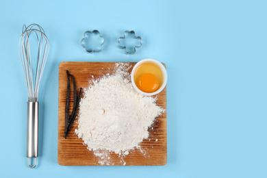 Flat lay composition with eggs and other ingredients on light blue background, space for text. Baking pie