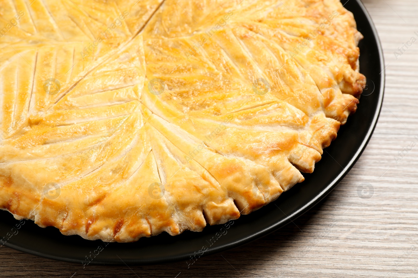 Photo of Traditional galette des rois on wooden table, closeup