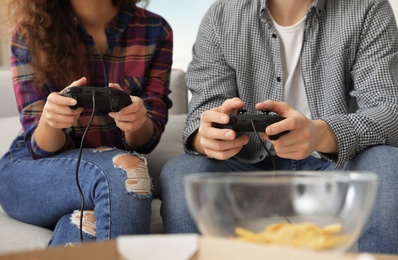 Photo of Young couple playing video games at home, closeup