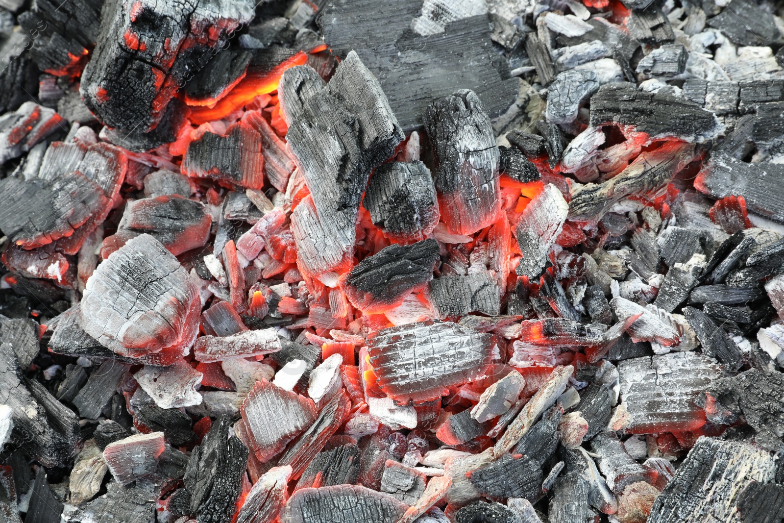 Photo of Many smoldering coals as background, closeup view