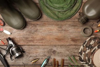 Flat lay composition with fishing equipment and space for text on wooden background