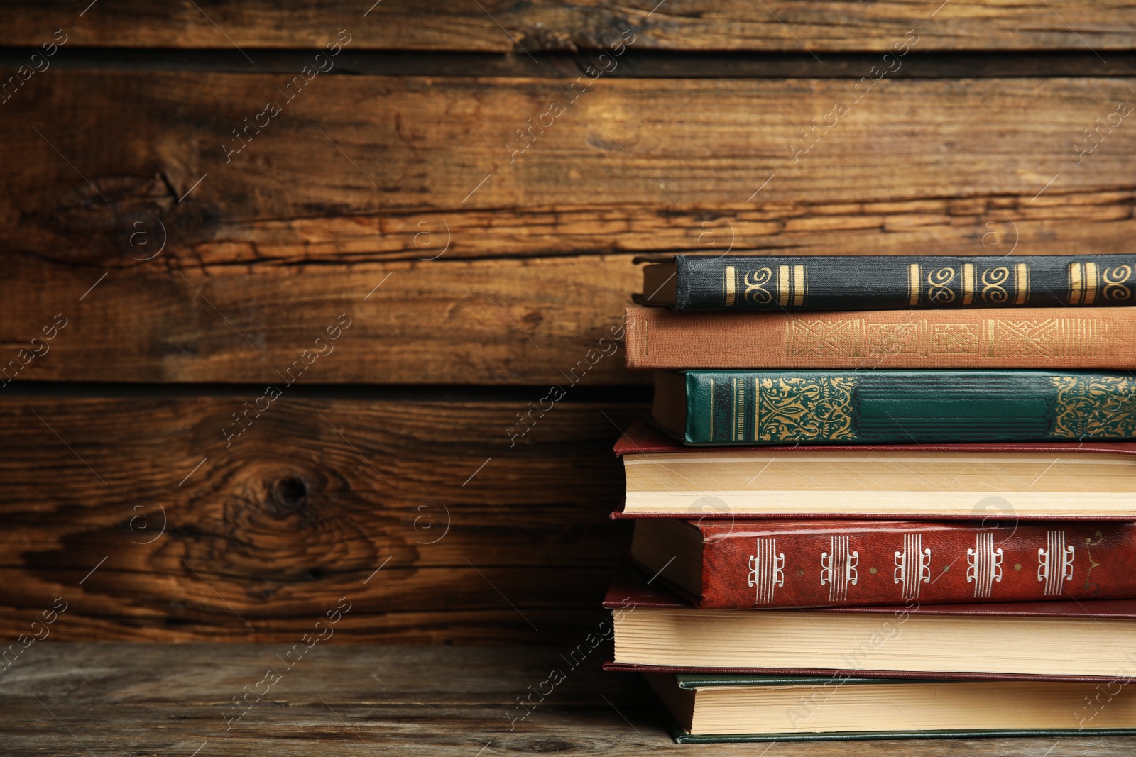 Photo of Collection of different books on table against wooden background. Space for text