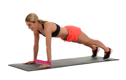 Photo of Woman exercising with elastic resistance band on fitness mat against white background