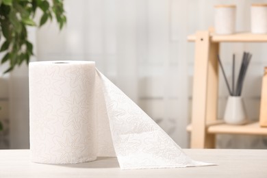 Photo of Roll of paper towels on white wooden table indoors. Space for text