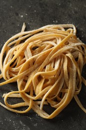 Photo of Uncooked homemade pasta on dark grey table