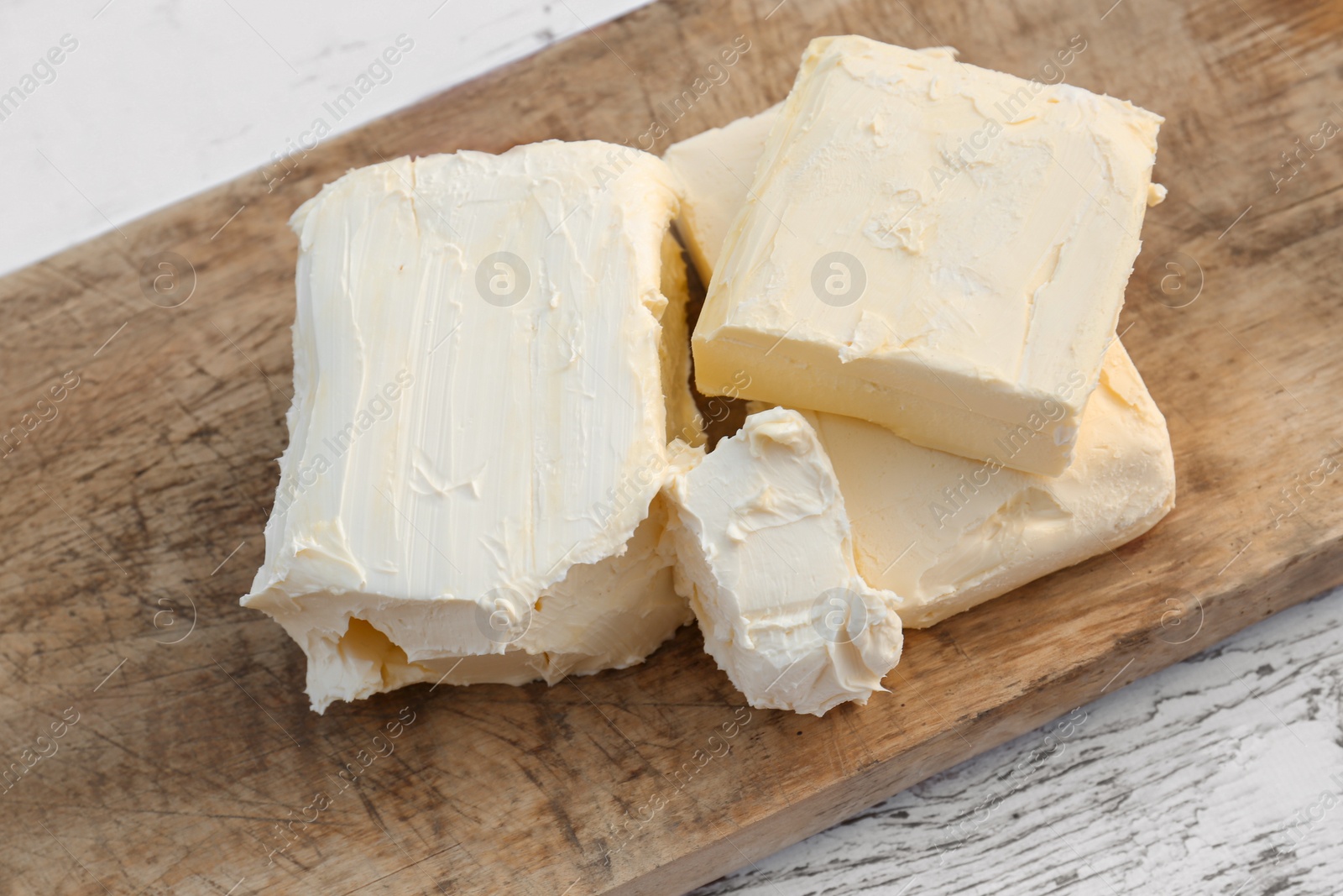 Photo of Board with tasty homemade butter on white wooden table, closeup