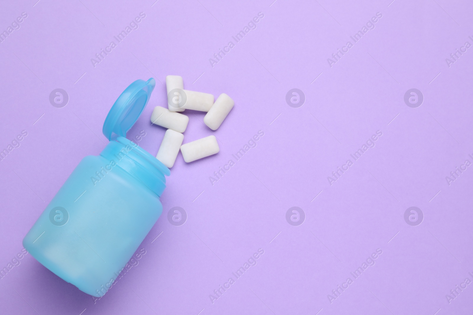 Photo of Jar with chewing gums on lilac background, flat lay. Space for text