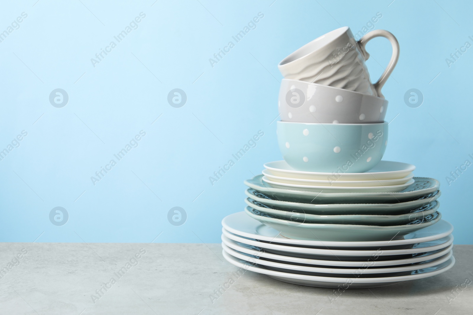 Photo of Beautiful ceramic dishware and cup on light grey table, space for text