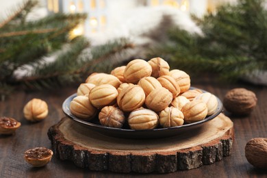 Homemade walnut shaped cookies with boiled condensed milk near fir branches on wooden table