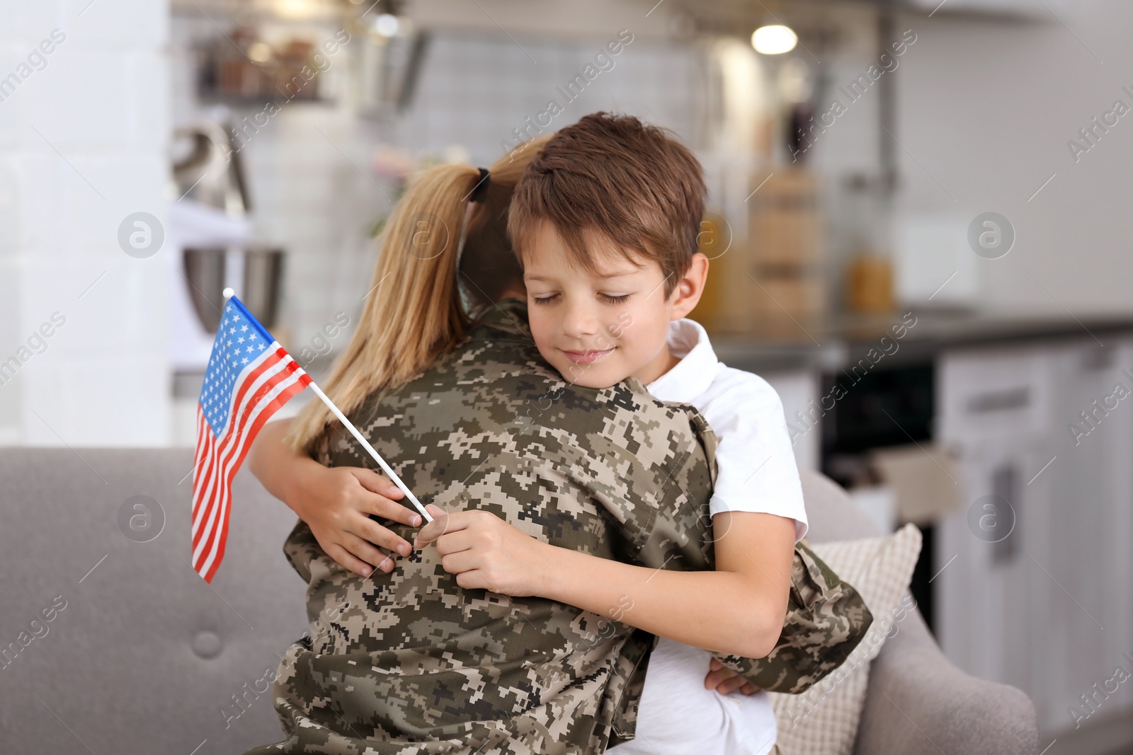 Photo of Woman in military uniform with her little son at home