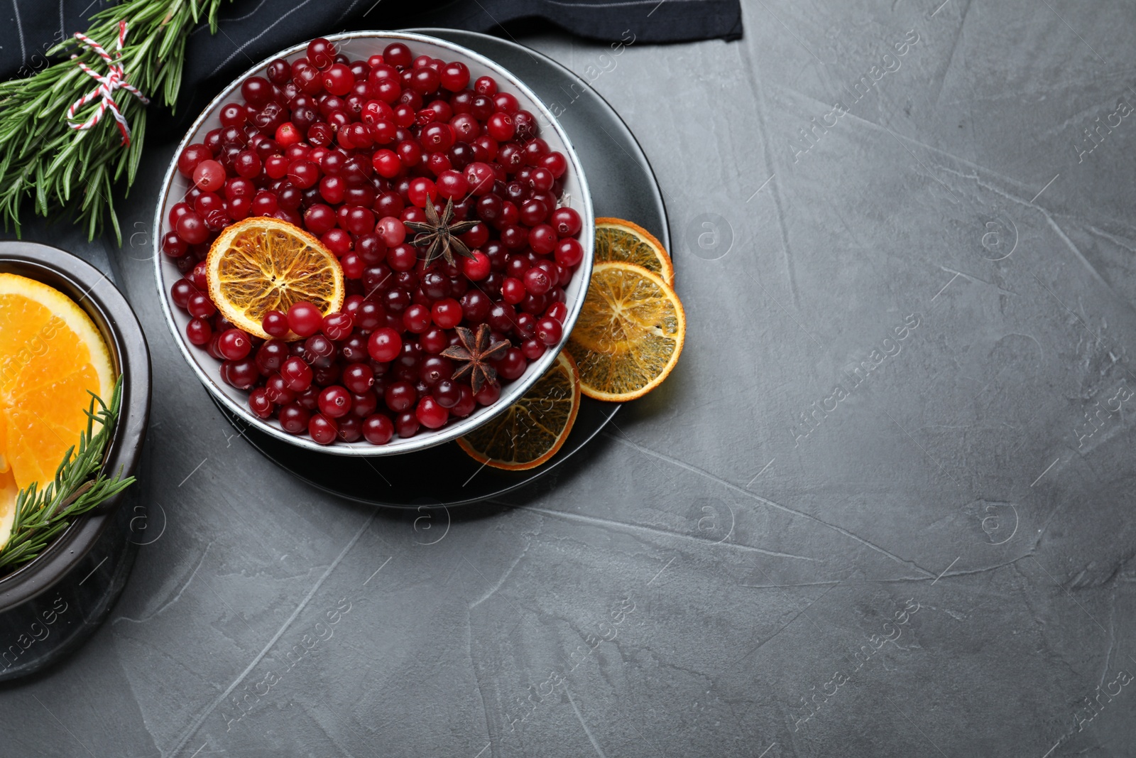 Photo of Flat lay composition with fresh ripe cranberries on grey table. Space for text