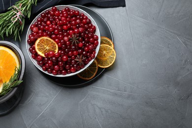 Flat lay composition with fresh ripe cranberries on grey table. Space for text