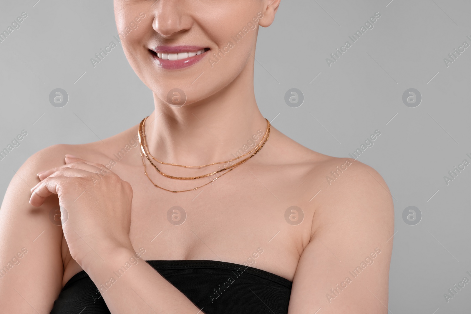 Photo of Woman with elegant necklace on light grey background, closeup