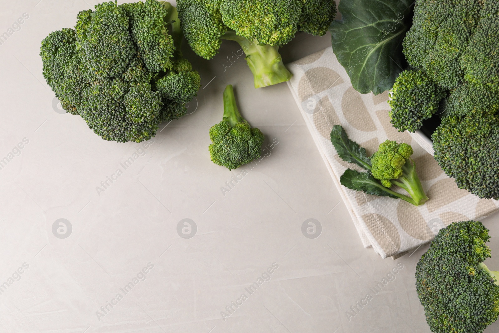 Photo of Fresh raw broccoli on white table, flat lay. Space for text