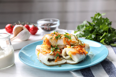 Photo of Delicious cabbage rolls served on white wooden table