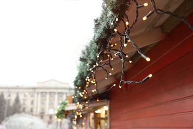 Photo of Christmas fair stall with string lights outdoors, closeup