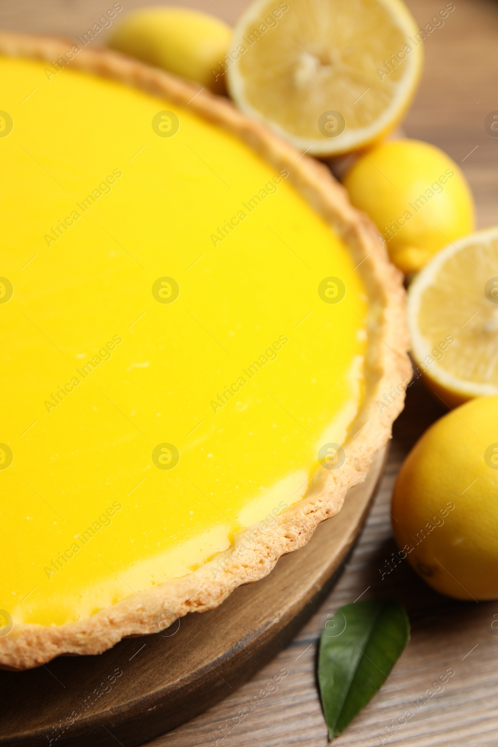 Photo of Delicious homemade lemon pie and fresh fruits on wooden table, closeup