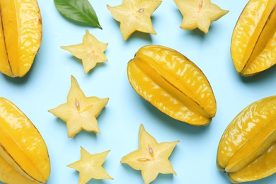 Delicious carambola fruits on light blue background, flat lay