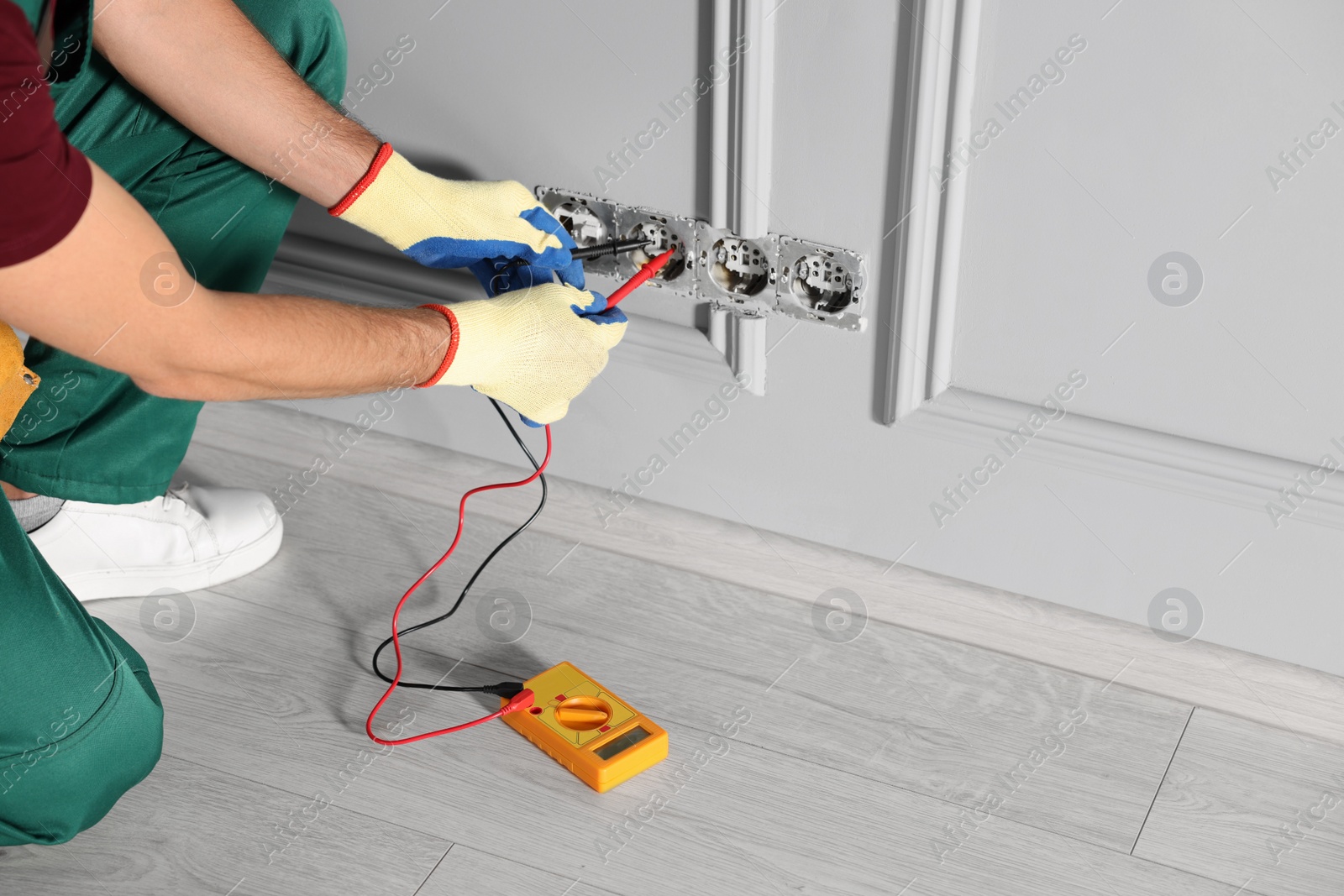 Photo of Electrician with tester checking voltage indoors, closeup