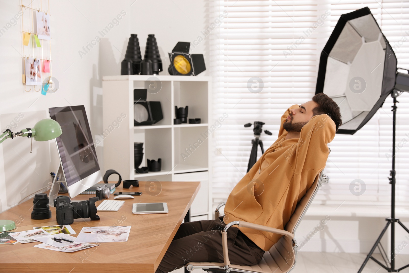 Photo of Professional photographer resting at workplace in office