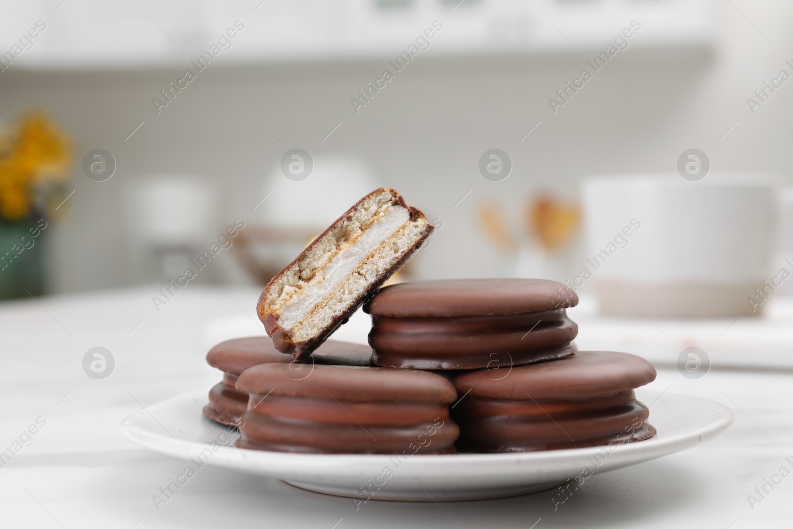 Photo of Saucer with delicious choco pies on white table in kitchen, closeup