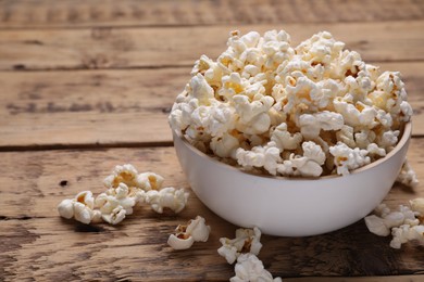 Photo of Tasty popcorn on wooden table, closeup. Space for text